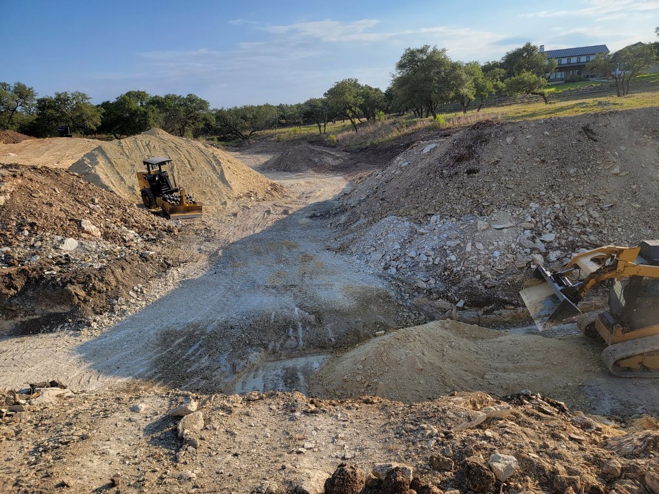 Heavy equipment cutting an access road through rock