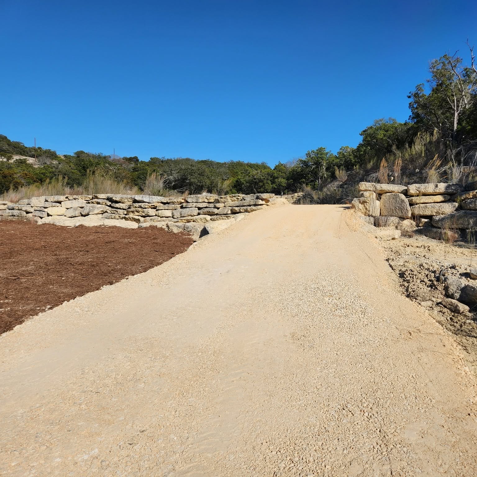 Graded caliche road running through a limestone cut