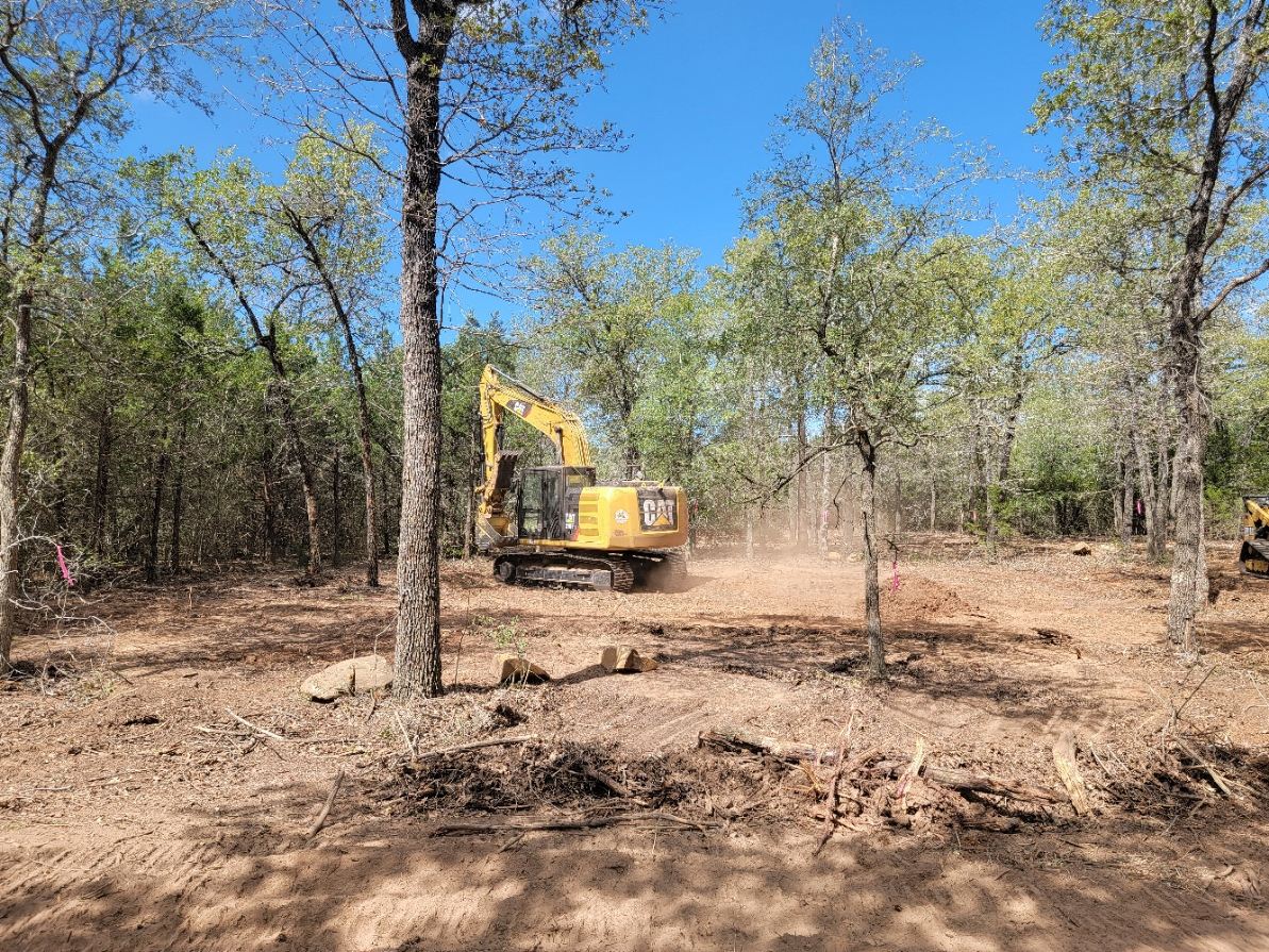 Excavator preparing a surveyed and flagged building site